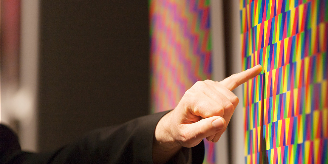 A finger points to a color pattern, relevant for lighting design.