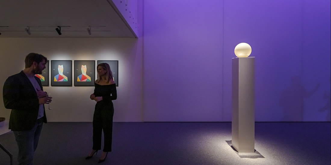 ERCO lighting design in an art gallery, featuring people and an illuminated sculpture.