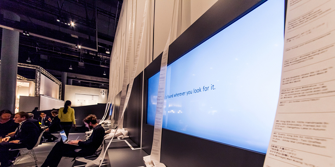 ERCO presentation with texts and visitors in an exhibition space.
