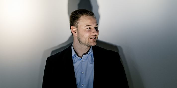 A young man in a suit, training or in a dual study program at ERCO.
