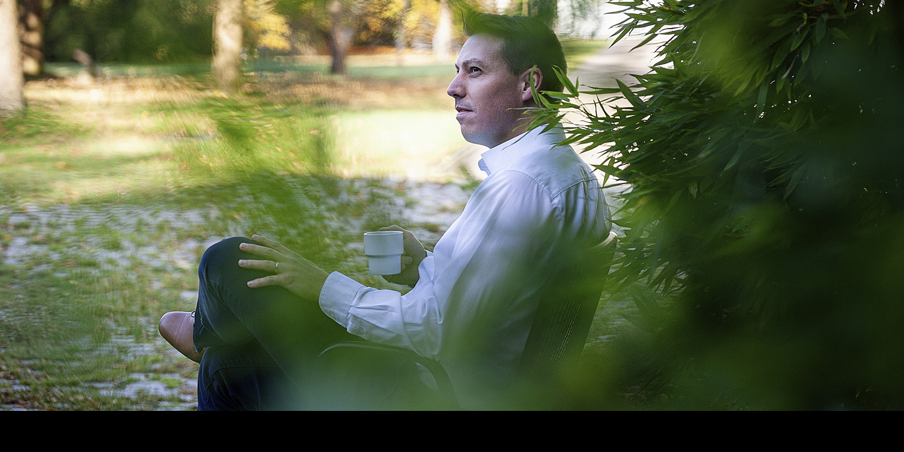 Man with cup in park, reflecting ERCO's social responsibility.