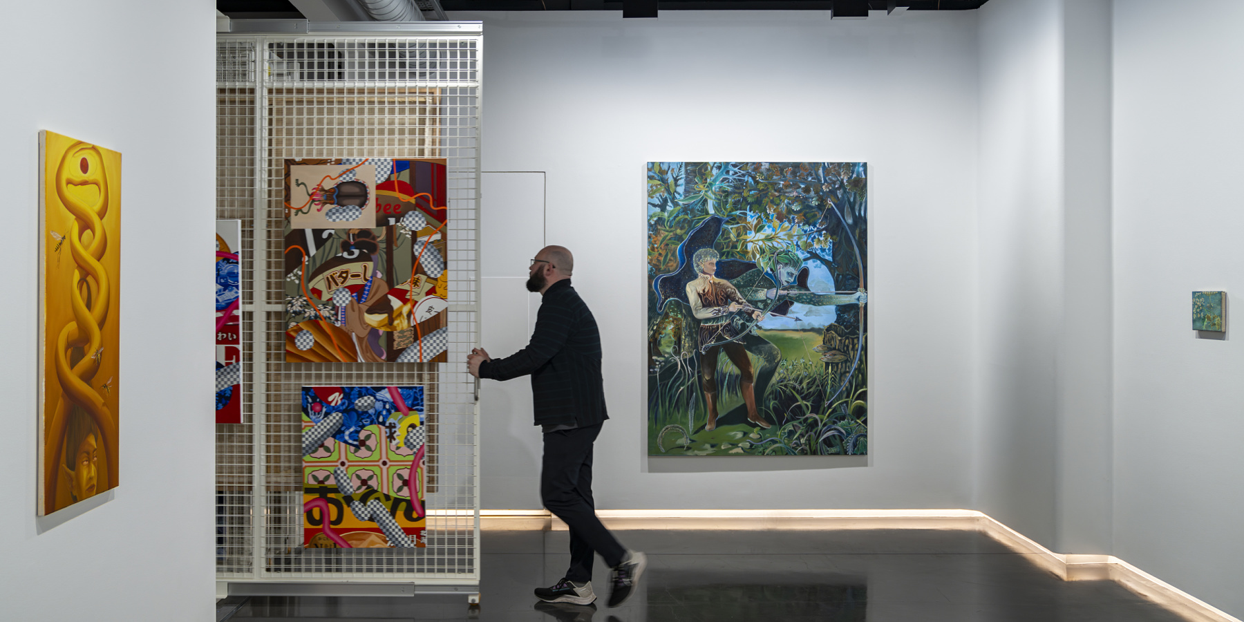 Gallery lighting with ERCO: A man views art in a brightly lit gallery space, enhancing the art's appeal.