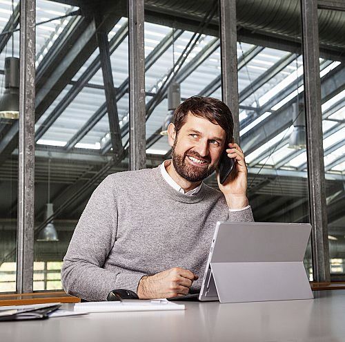 ERCO employee in conversation while working on a tablet.