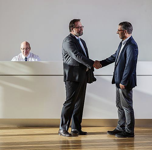 ERCO Purchasing: Two business partners shake hands, sealing an agreement.