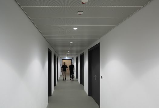 Hallway in Blockhaus Dresden featuring ERCO Skim downlights for uniform lighting.