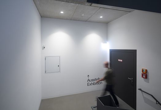 ERCO LED lighting in Blockhaus Dresden: Hallway with exhibition sign and architectural lighting.