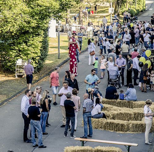 ERCO career event: Crowd of people with a stilt walker in a social atmosphere.