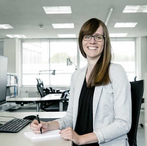 ERCO career starter: Smiling employee working at her desk in the office.