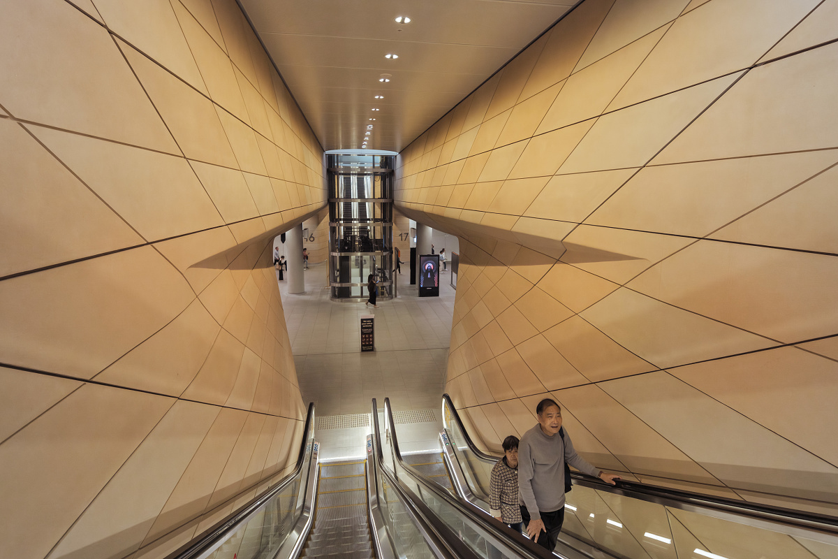 People on escalator in Sydneys Central Station, featuring ERCO lighting.
