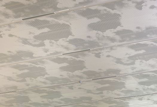 Cloud-patterned ceiling with linear LED downlights at Changi Airport, Singapore.