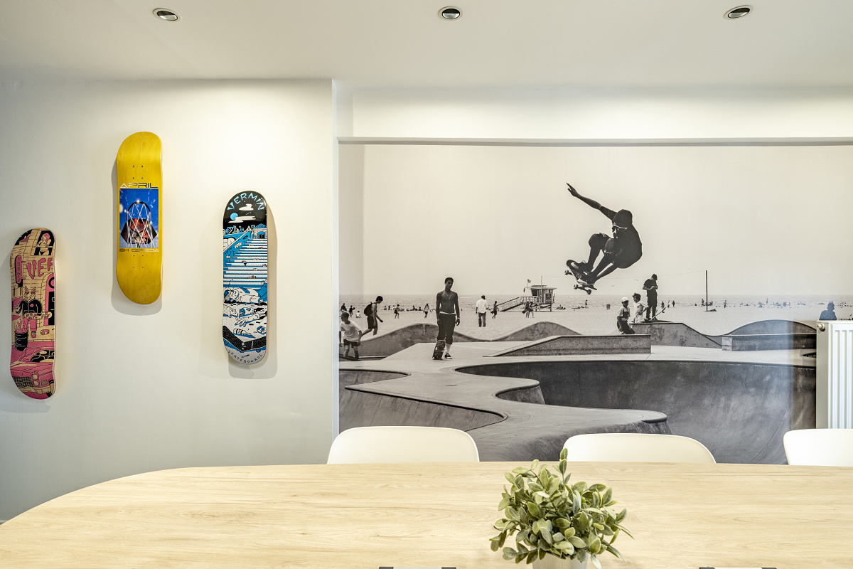 ComOver office in Lyon featuring skateboard decor and mural, illuminated by ERCO LED lighting.
