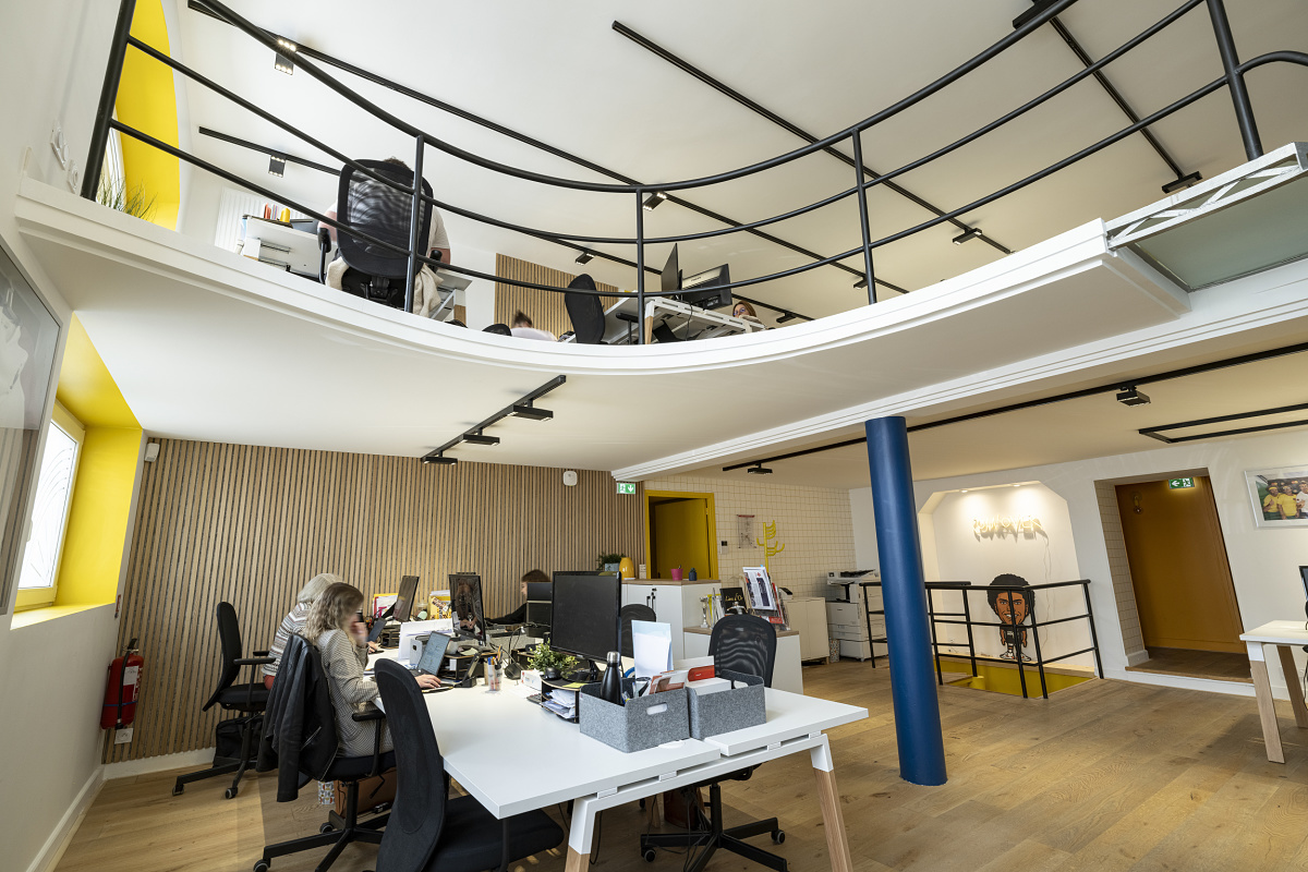 ComOvers modern office in Lyon, featuring flexible workspaces illuminated by ERCO LED lighting.