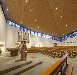 Church interior featuring pews, altar, and organ, illuminated by ERCO lighting for a contemplative atmosphere.
