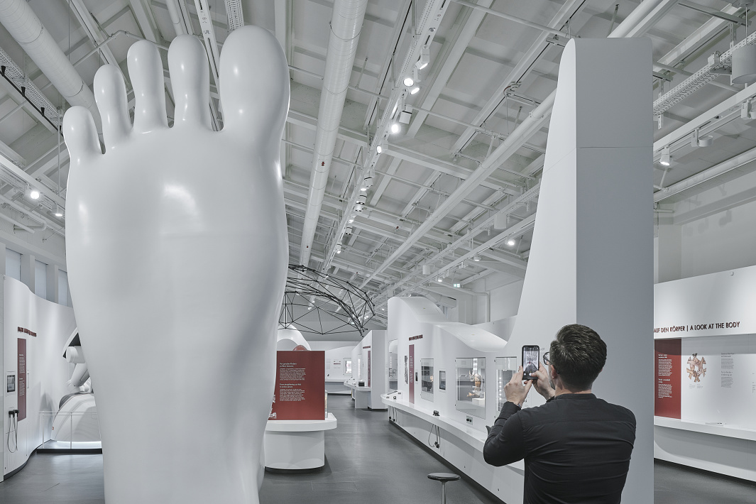 Deutsches Museum, Munich: Exhibition featuring ERCO LED lighting and an oversized foot sculpture.
