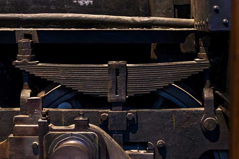 Close-up of a steam locomotive's leaf spring suspension at the German Museum of Technology in Berlin.