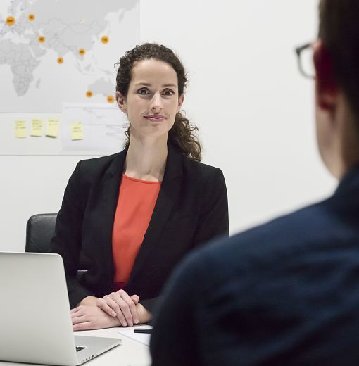 A woman in an office setting, showcasing ERCO LED downlights for flexible office lighting.