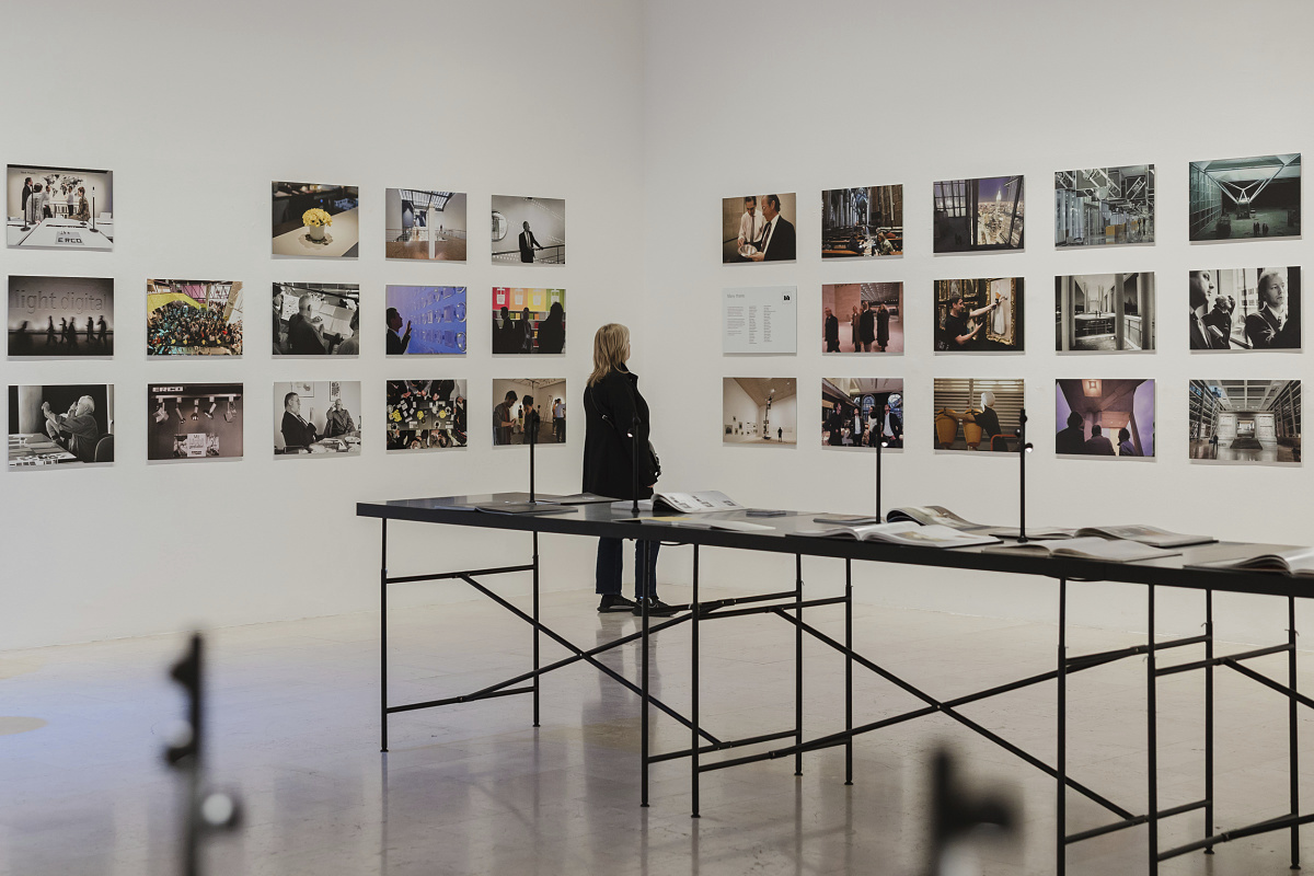 Visitor views the ERCO Light Box exhibition in Milan, showcasing light and architecture through photography.