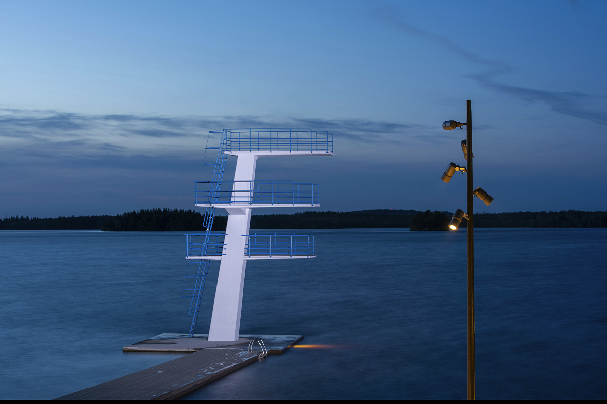 Illuminated diving platform at Evedal swimming pool, Växjö, featuring ERCO LED outdoor lighting for atmospheric light.