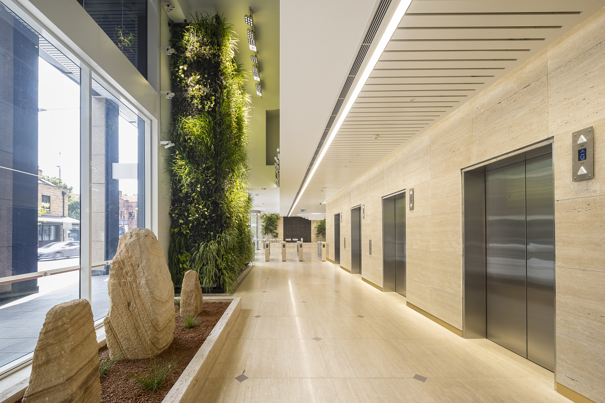 Illuminated green wall in an office building, enhanced by ERCO lighting solutions for healthy plant growth.