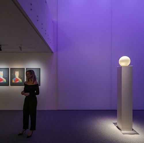 ERCO lighting design: Sphere luminaire on a column, staged with purple light in an exhibition space.