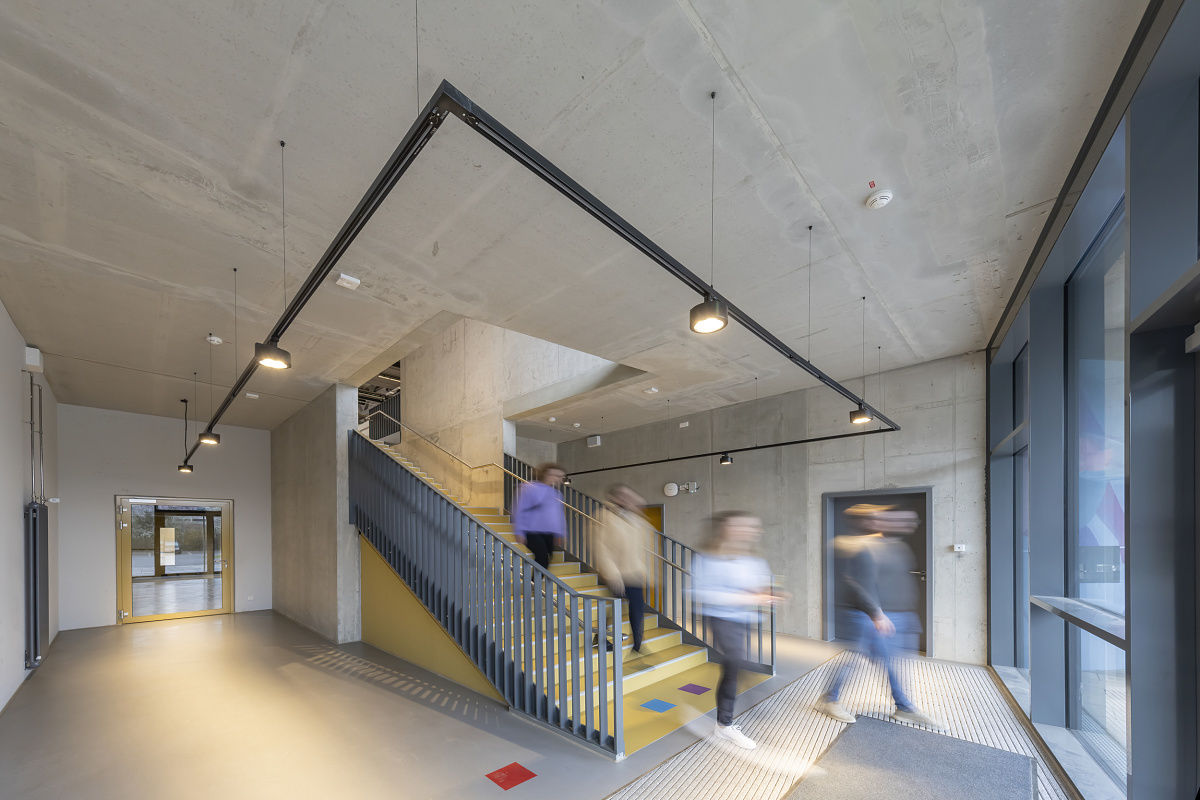 ERCO Jilly downlights illuminate the stairwell in the Neustadt gymnasium with flexible light.