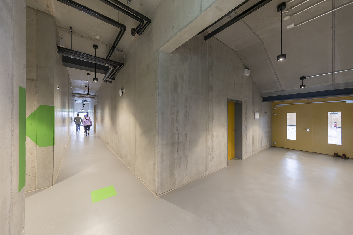 Hallway in Neustadt gymnasium featuring ERCO Skim downlights for uniform lighting.
