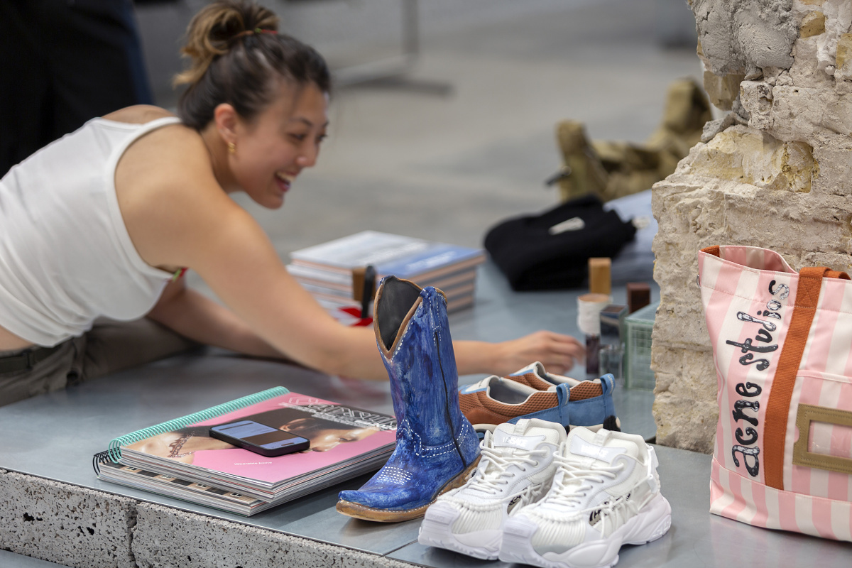 Highsnobiety store Berlin: Fashionable shoes and accessories on display table with ERCO lighting.