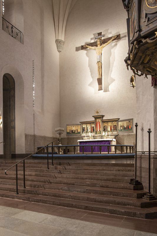 Högalid Church interior featuring the altar and crucifix, illuminated by ERCO spotlights.