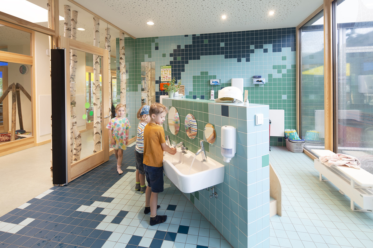Children washing hands in the Rappelkiste Day Care Centres washroom, lit by ERCO LED lighting.
