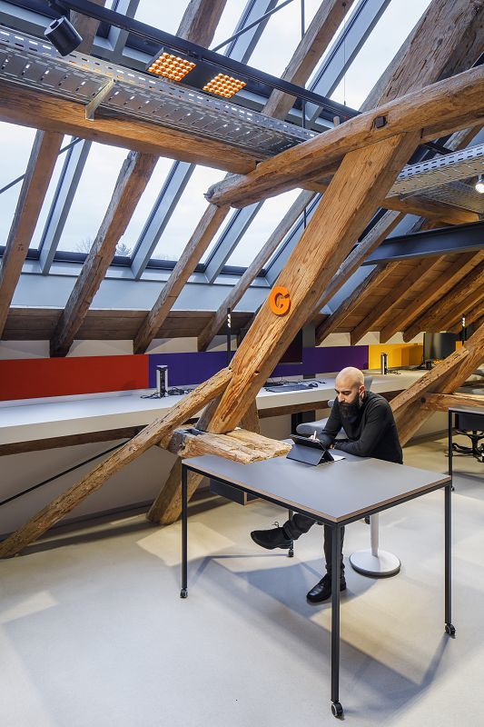 Koppenmühle Darmstadt office with ERCO lighting under historic timber structure.