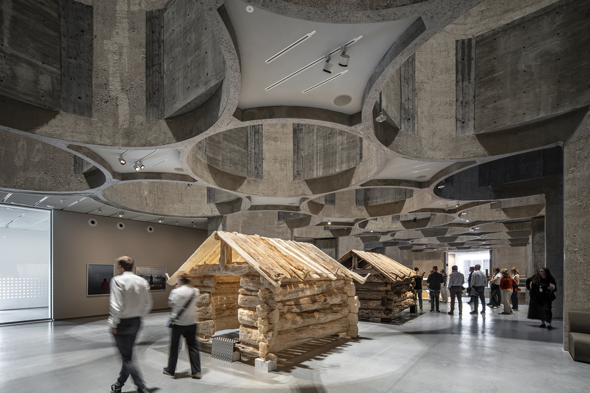 Kunstsilo Kristiansand art museum featuring ERCO track spotlights illuminating wooden cabin art.