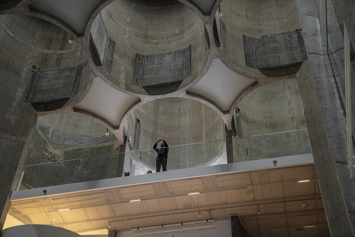 Kunstsilo Kristiansands architecture, enhanced by ERCO lighting, captivates a visitor.