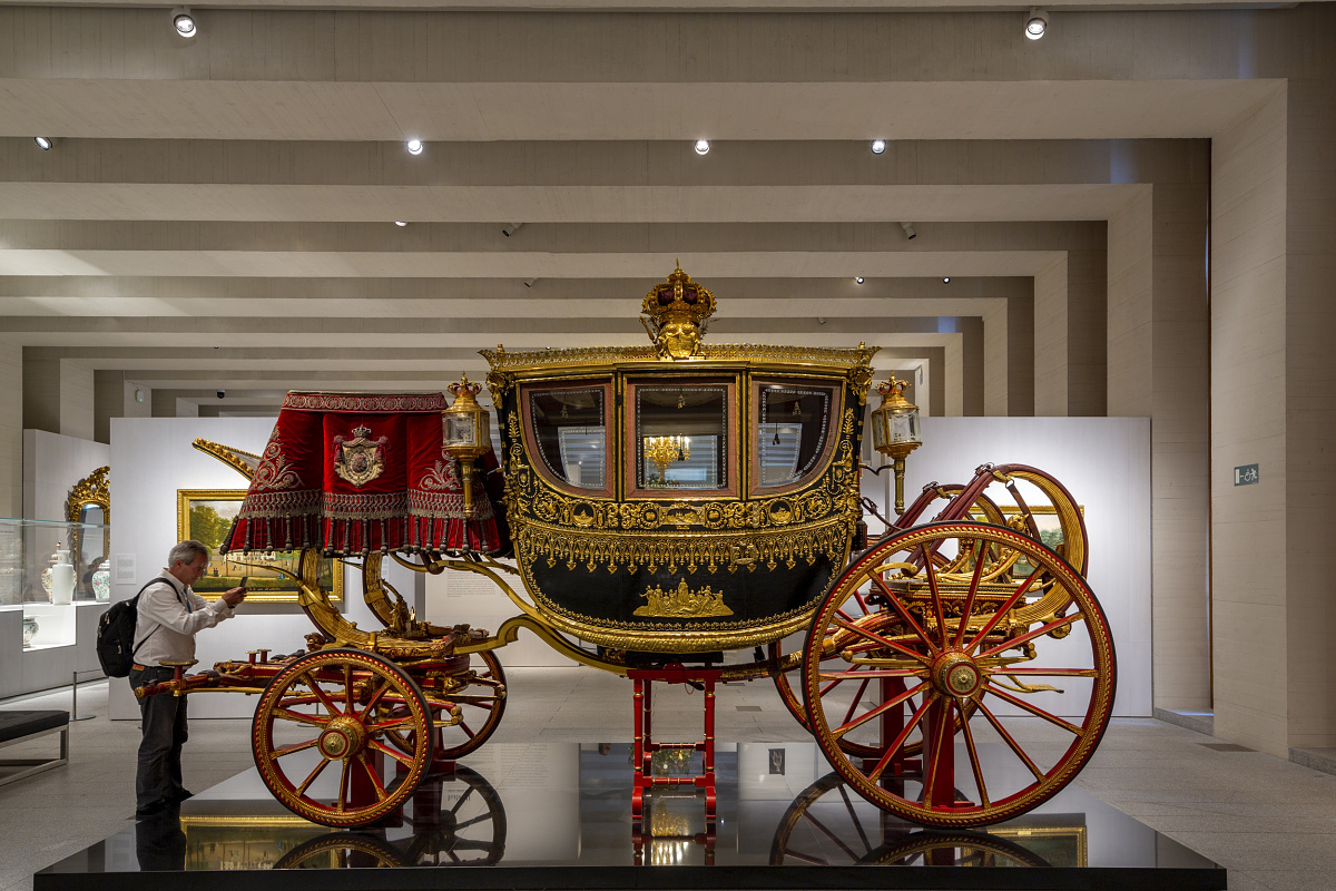 Ornate carriage on display at Galería de las Colecciones Reales, illuminated by ERCO LED lighting.