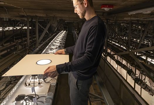 Technician installing ERCO Atrium LED downlights at Hamburg State Opera, upgrading auditorium lighting.