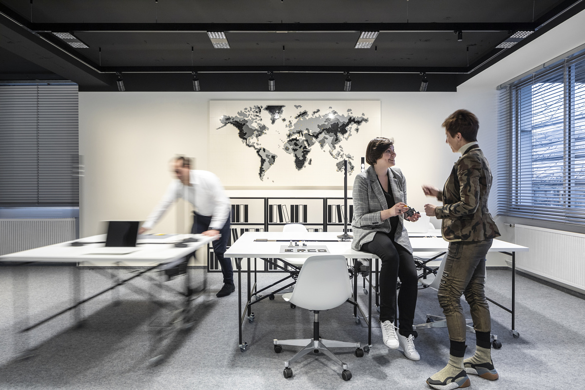 Flexible office lighting with ERCO Jilly downlights on a track system in a modern office environment.