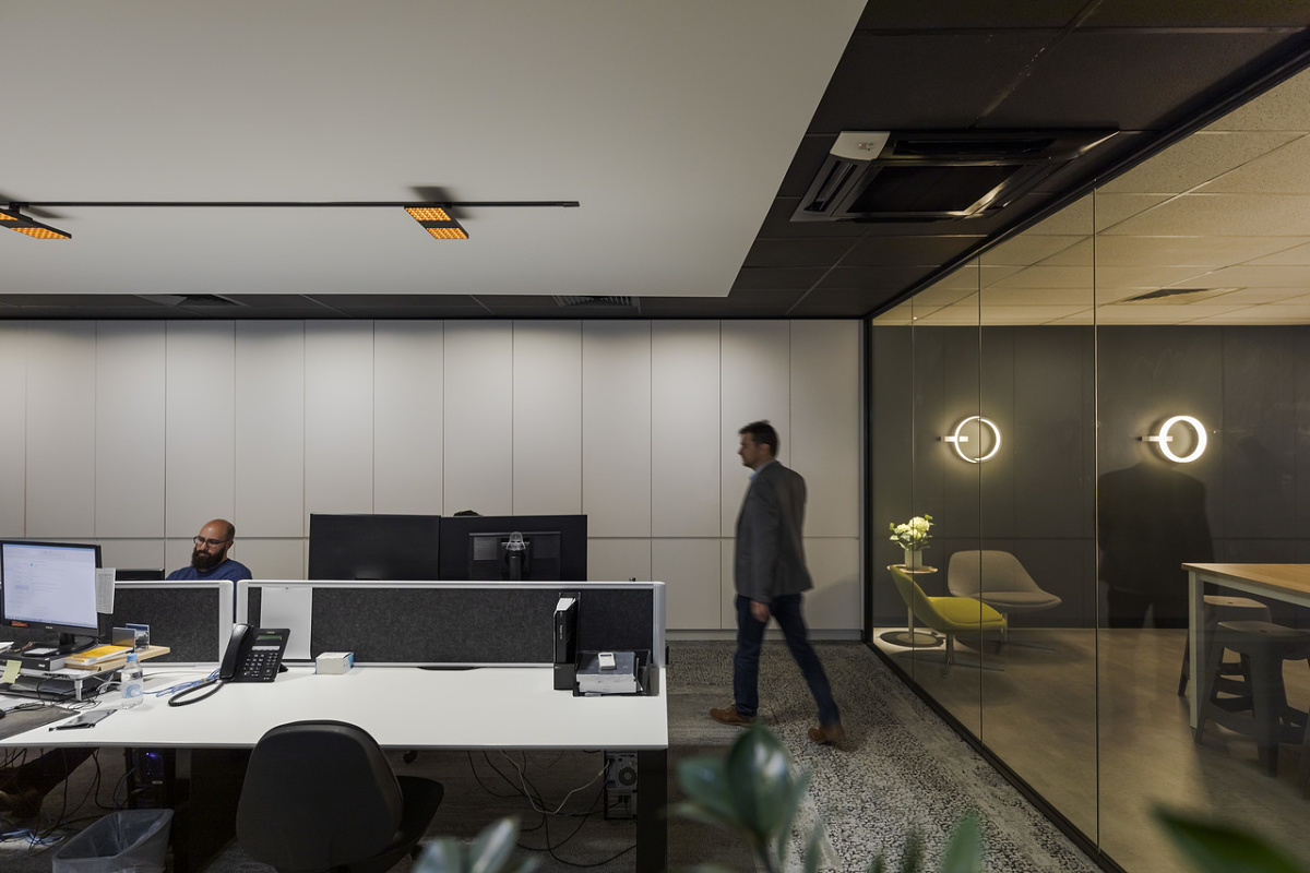 ERCO Jilly downlights on a track system providing flexible office lighting for modern workspaces.