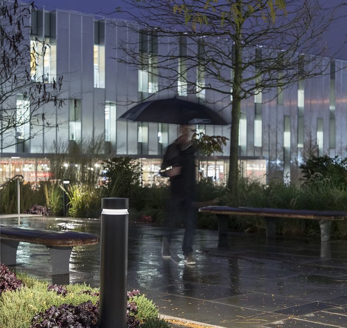 ERCO Castor bollard luminaire illuminates a public square at night, providing orientation.