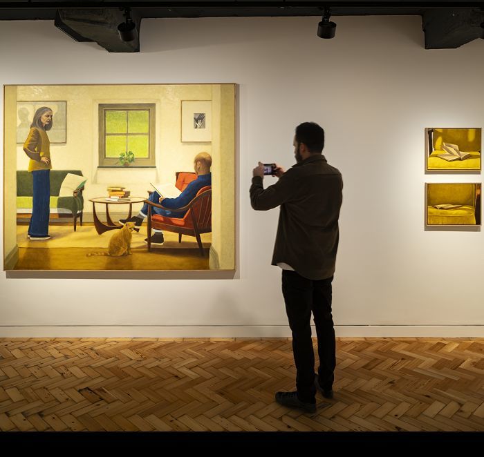 Gallery lighting: Visitor photographs artwork under ERCO lighting.