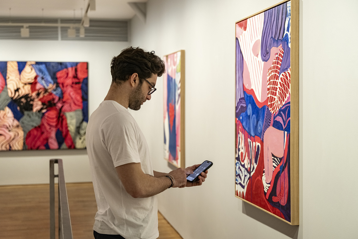Man views art at Lilia Ben Salah Gallery, illuminated by ERCO LED spotlights.