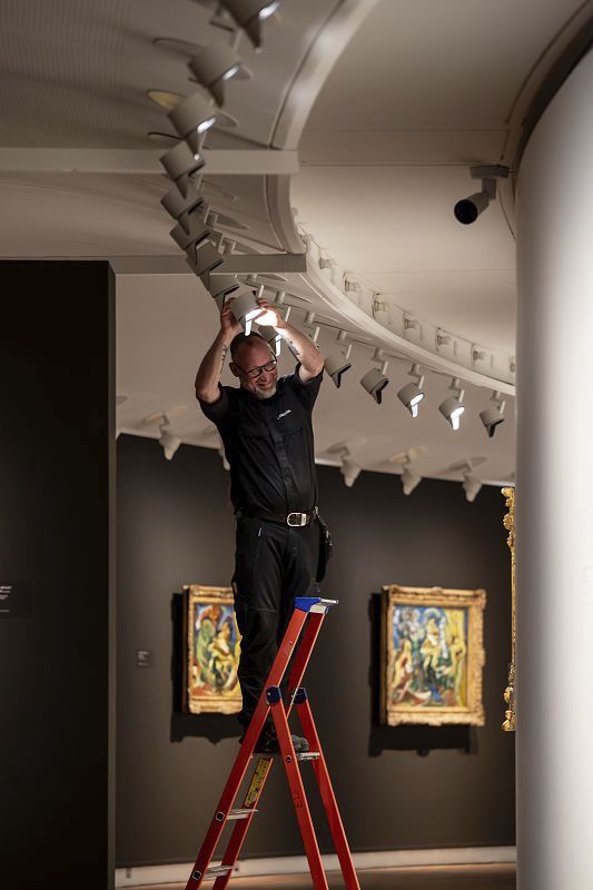 Electrician adjusts an ERCO Parscan LED spotlight at the Louisiana Museum, optimizing art illumination.