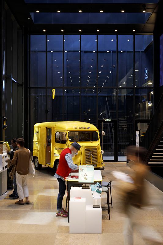ERCO LED spotlights illuminate a vintage yellow postal van in the Louvre Post Office, Paris.
