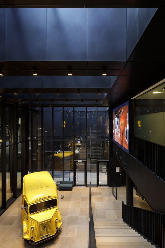 ERCO LED spotlights illuminate a yellow postal van in the Louvre Post Office, Paris.
