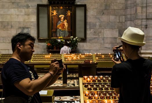 Visitors photograph the Milan Cathedrals lighting, enhanced by ERCO LED spotlights.
