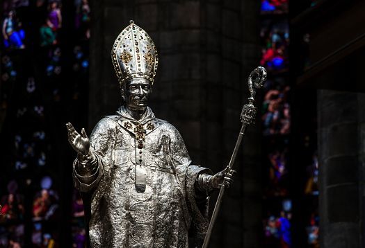Statue of a bishop in Milan Cathedral, illuminated by ERCO LED spotlights.