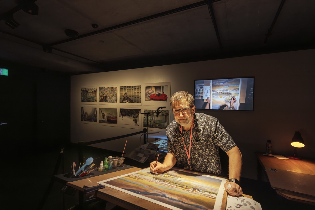Artist Chris Downes painting at MONA museum, illuminated by ERCO spotlights.