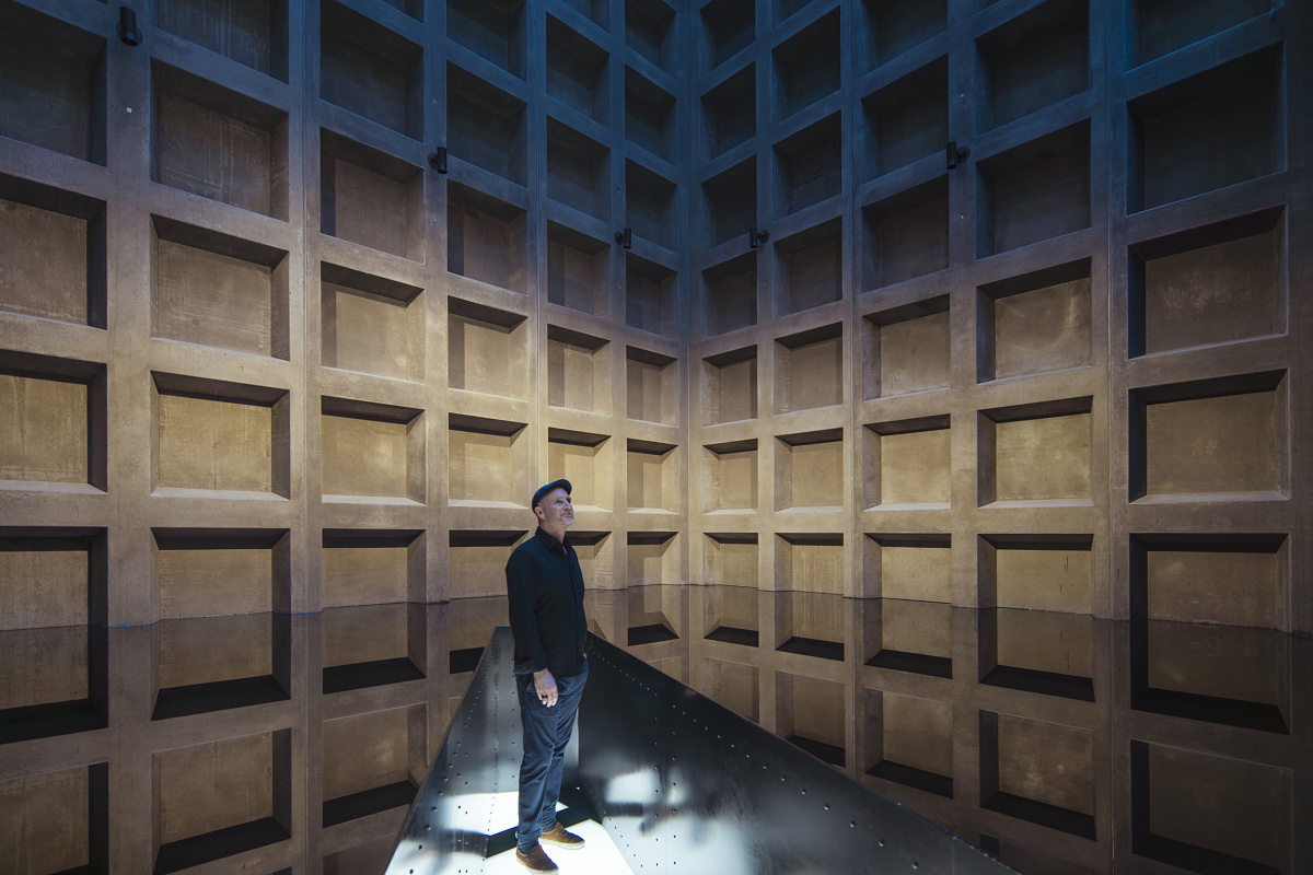 Man viewing lighting at Mona Museum, Tasmania. ERCO spotlights highlight art in the exhibition space.