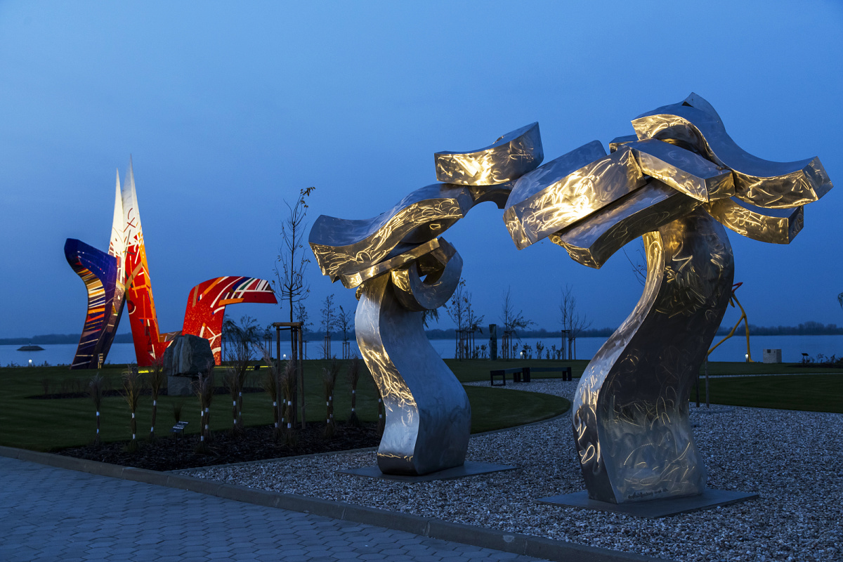 Illuminated sculptures in a museum park, featuring ERCO outdoor lighting for cultural experiences.