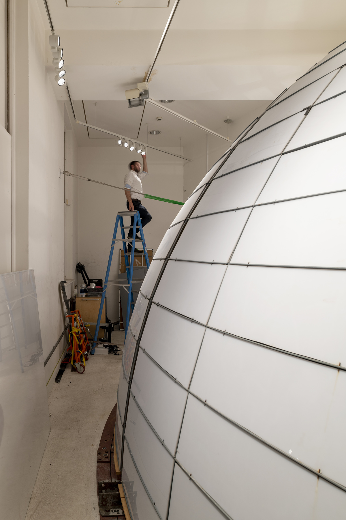 A man adjusts ERCO Optec spotlights on the ceiling at the National Maritime Museum, London.