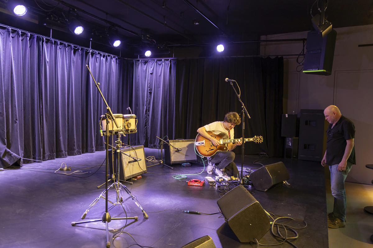 Guitarist on stage at NICA Jazz Club, Hamburg, illuminated by ERCO Optec New spotlights for an intimate atmosphere.