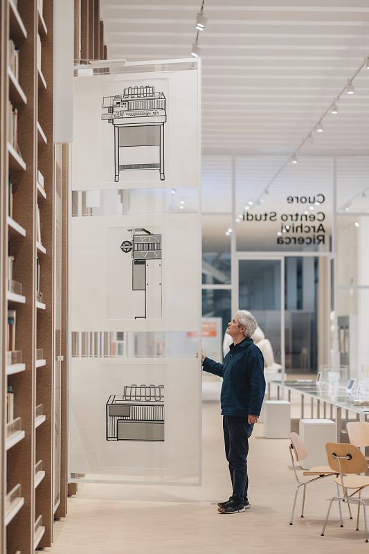 Visitor views archive drawings at Triennale Museum, illuminated by ERCO lighting solution.